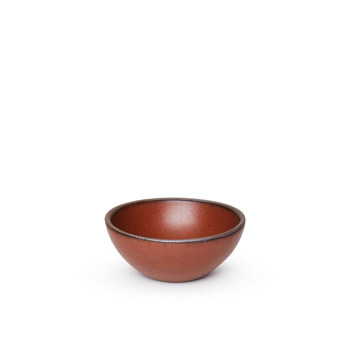 A small dessert sized rounded ceramic bowl in a cool burnt terracotta color featuring iron speckles and an unglazed rim
