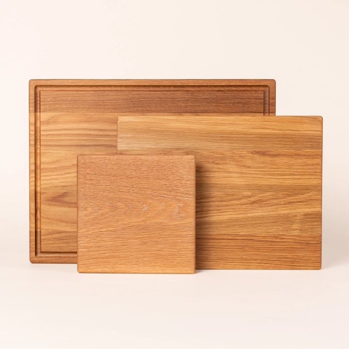 Three white oak cutting boards of various sizes all propped up next to each other.