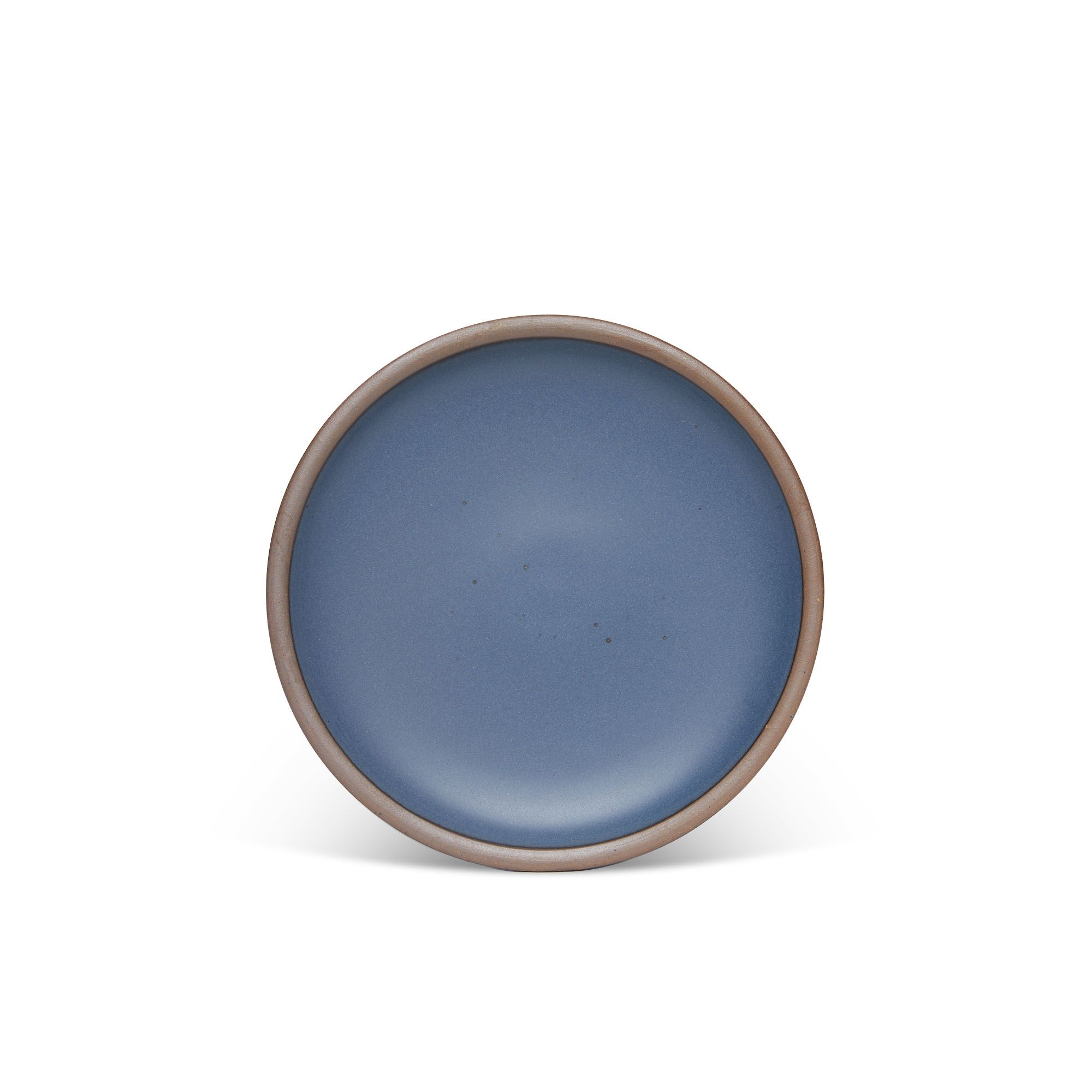 A medium sized ceramic plate in a toned-down navy color featuring iron speckles and an unglazed rim.