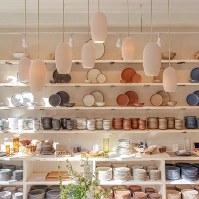 The pottery set wall in East Fork's store in Asheville featuring ceramic dinnerware in off-white, pale warm brown, and terracotta colors.