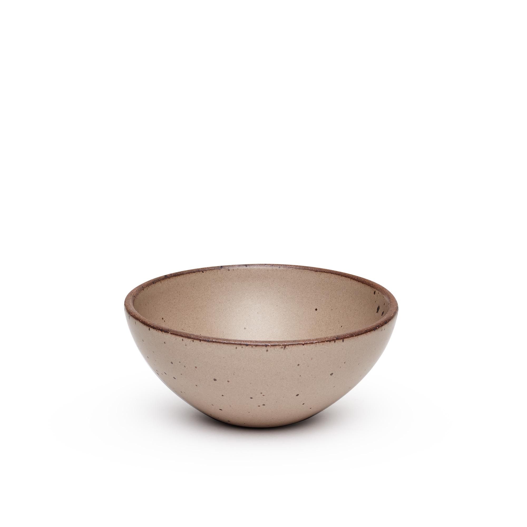 A medium rounded ceramic bowl in a warm pale brown color featuring iron speckles and an unglazed rim