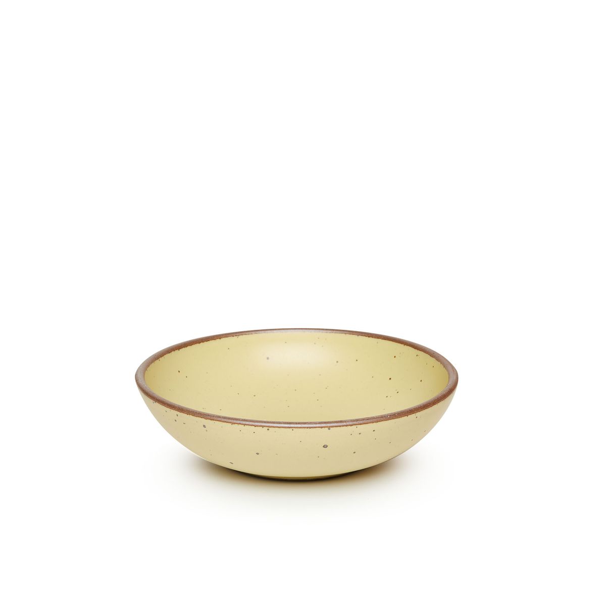A dinner-sized shallow ceramic bowl in a light butter yellow color featuring iron speckles and an unglazed rim