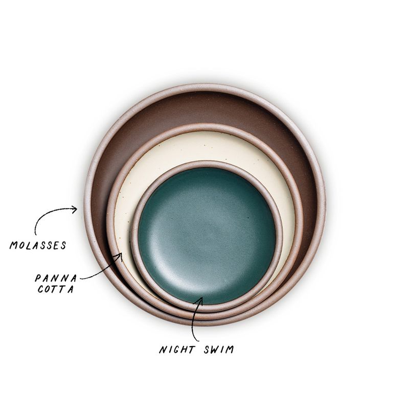 A stack of 3 plates in Dinner, Side, and Cake sizes in a dark brown, warm off-white, and dark teal colors.