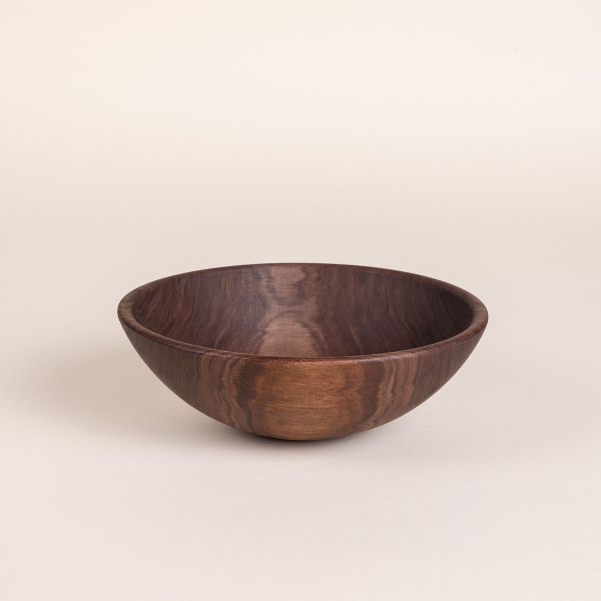 A medium sized round walnut wood bowl