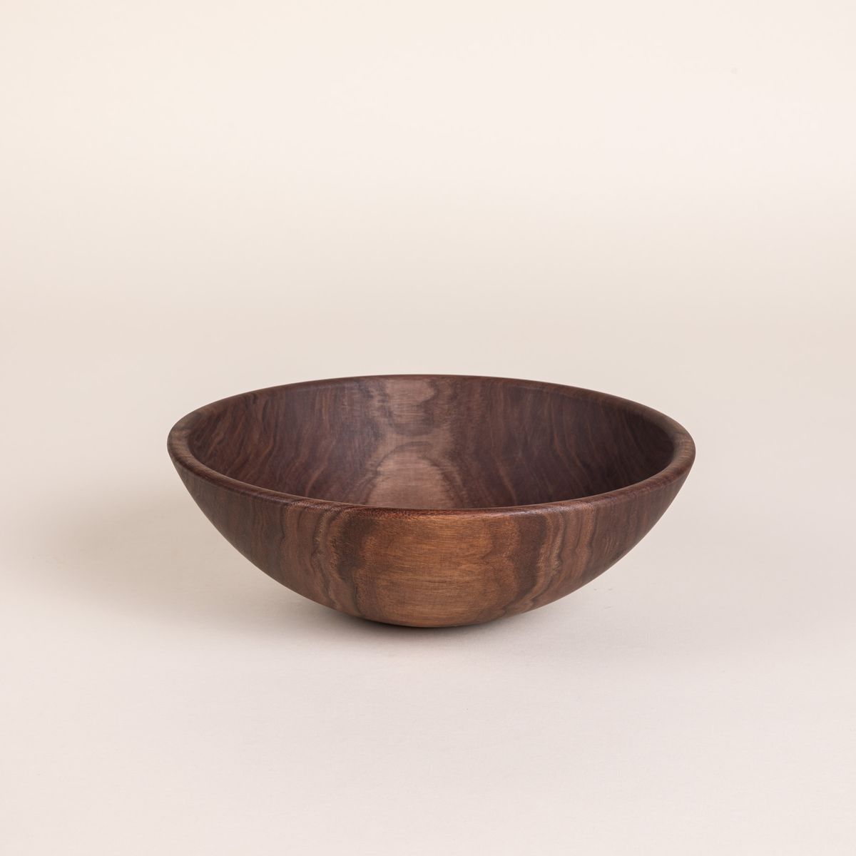 A medium sized round walnut wood bowl