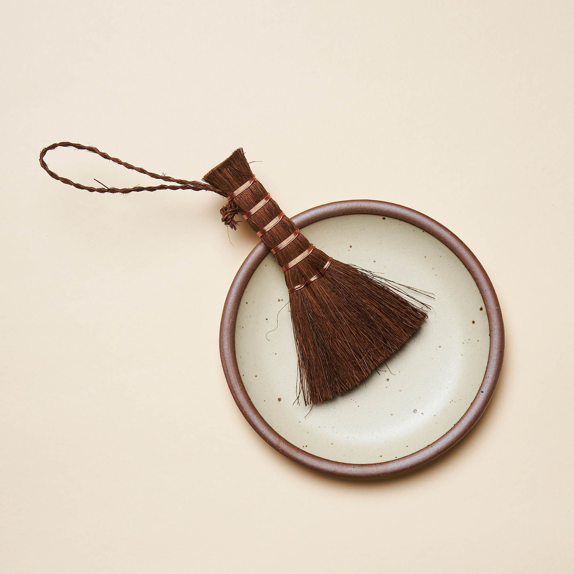 A small hand broom with a palm wooden handle