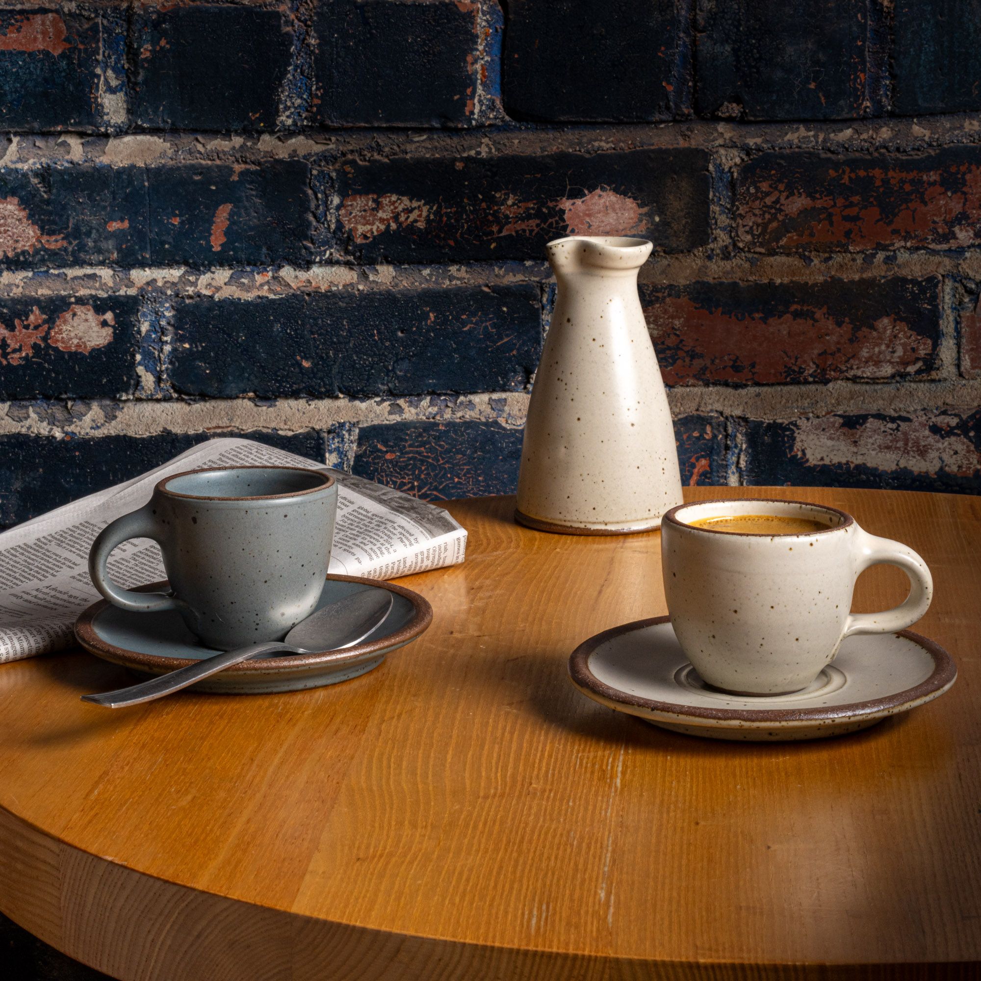 A table with East Fork Workshop pieces, The Creamer, and 2 Espresso Cup and Saucer pairs.