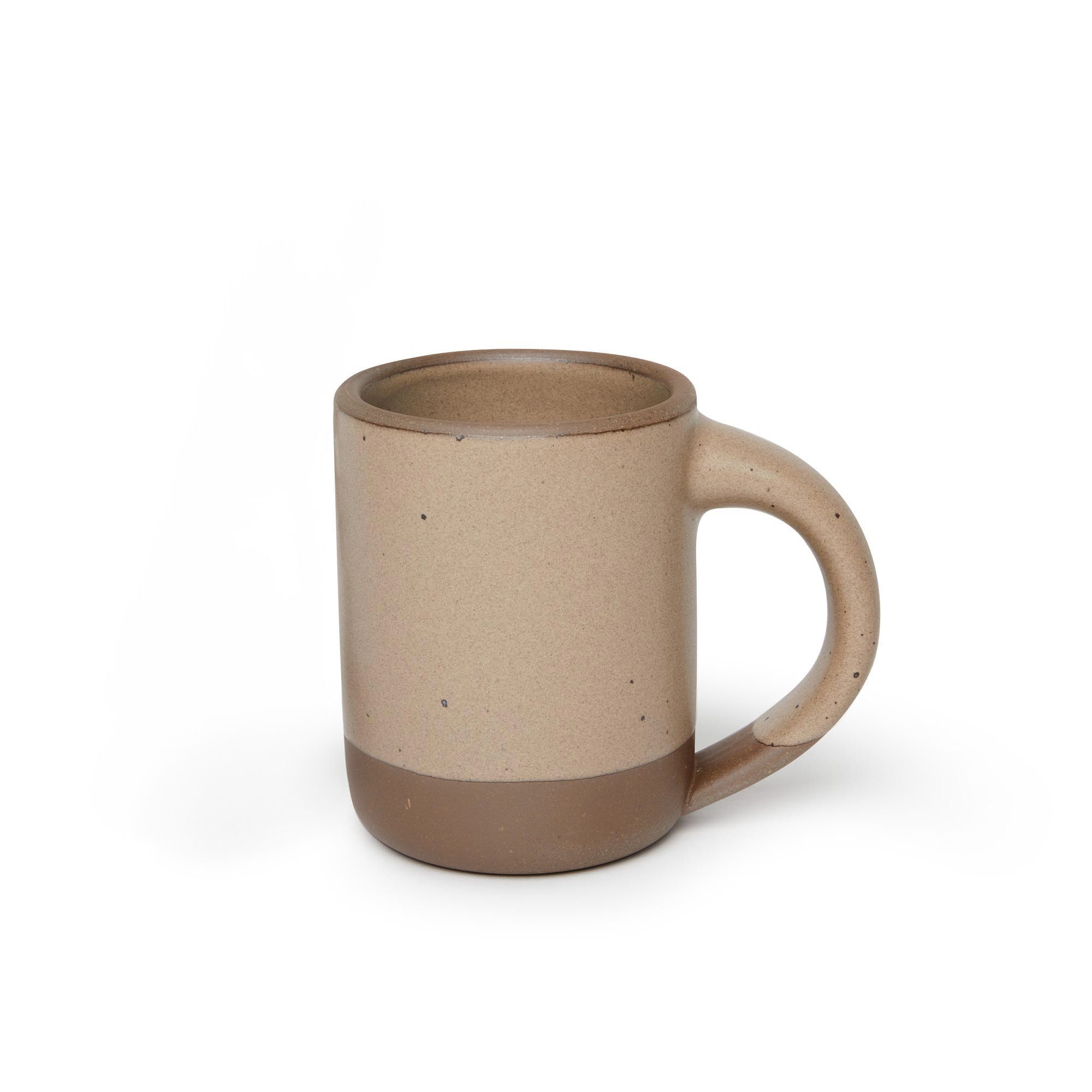 A medium sized ceramic mug with handle in a warm pale brown color featuring iron speckles and unglazed rim and bottom base.