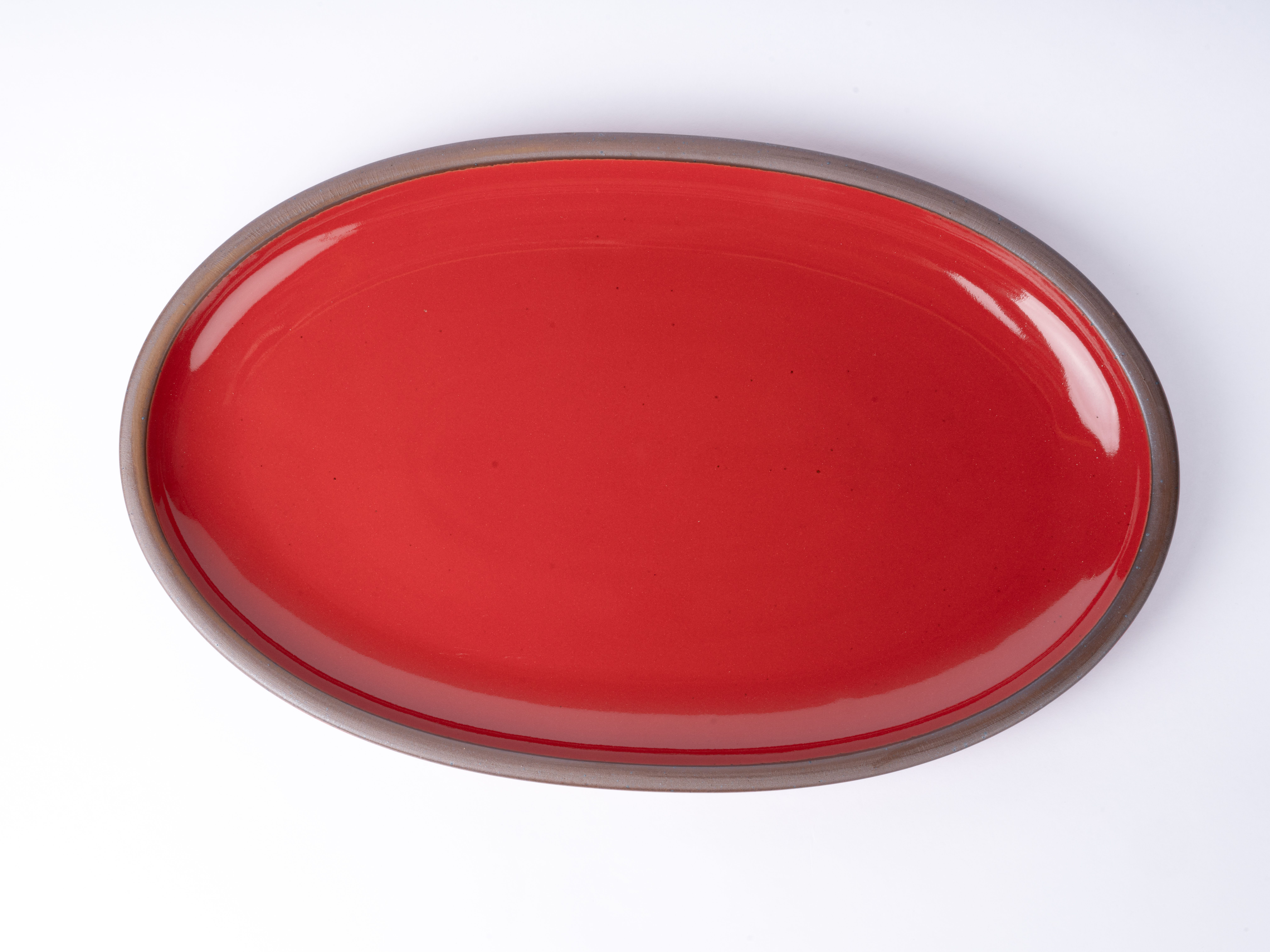 Closeup of a glossy red plate with subtle iron speckles