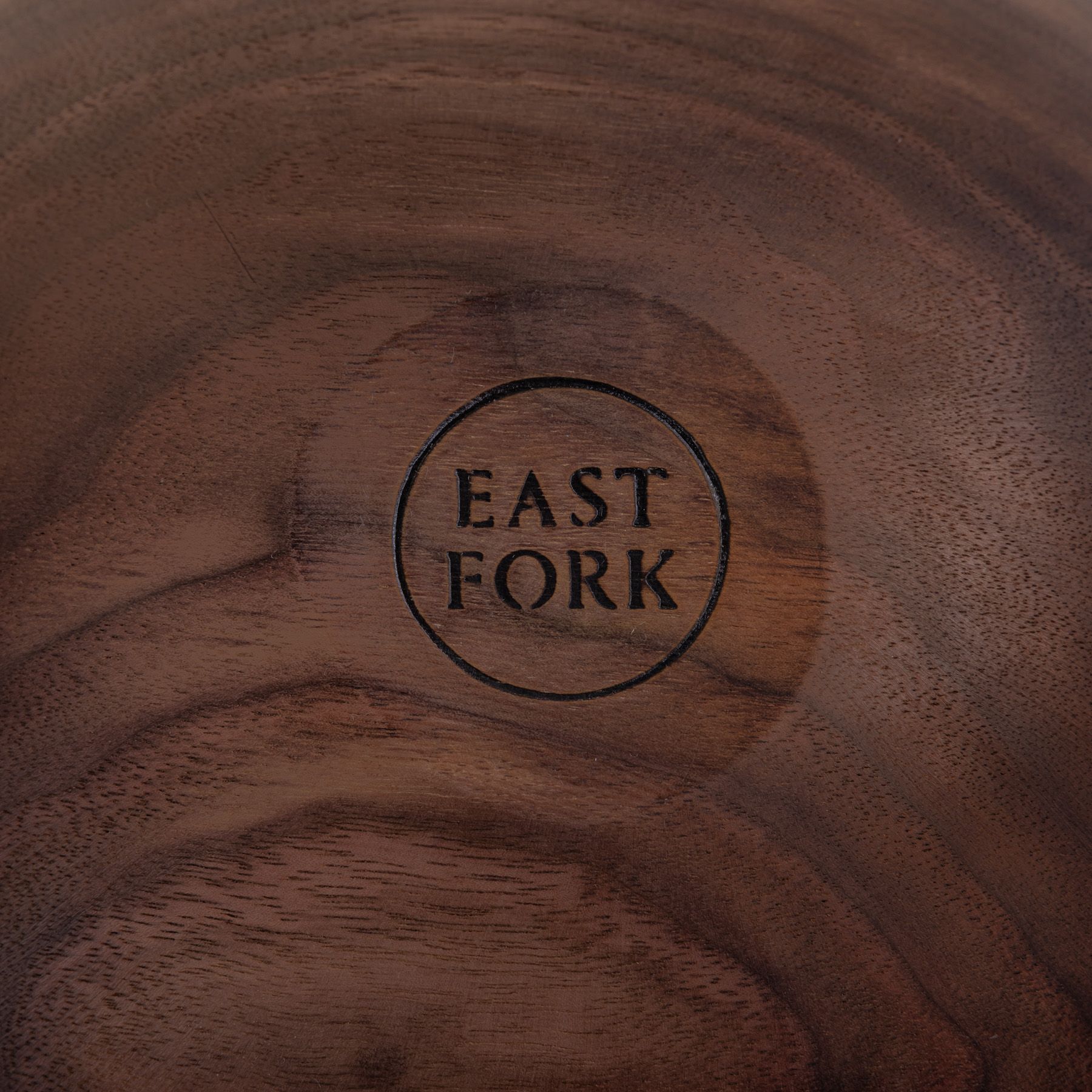 A close up of an East Fork stamp on the bottom of a walnut wood bowl