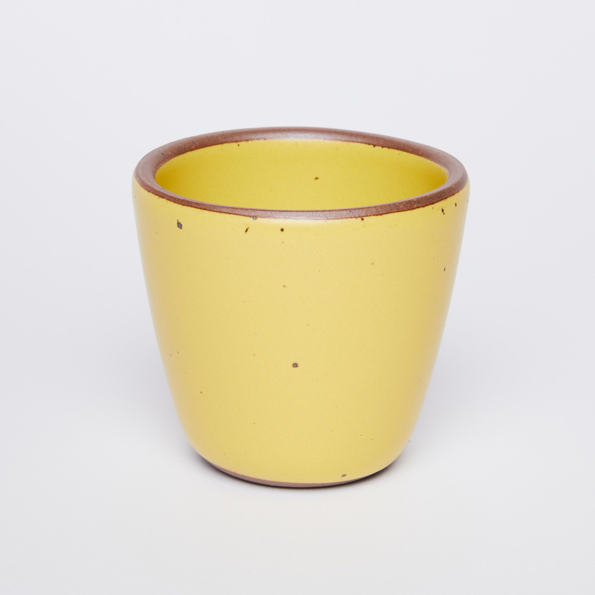 short cup that tapers out to get wider at the top in Pollen (yellow) glaze