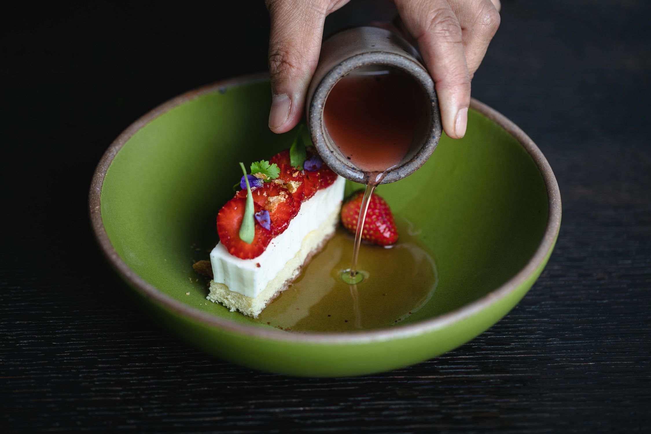 Pouring syrup from a toddler cup into a dessert in an East Fork everyday bowl.