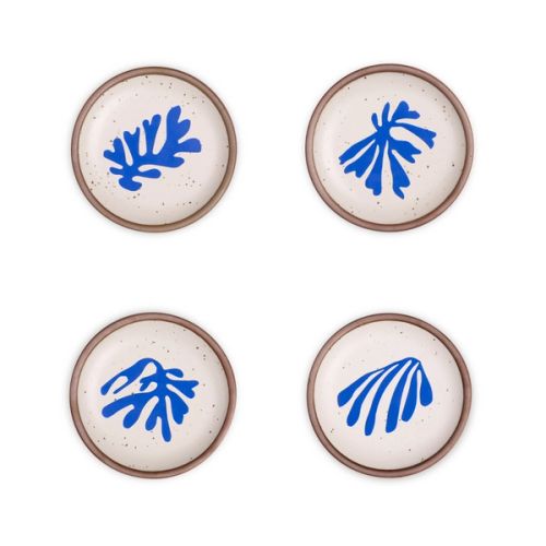 Four ceramic dessert sized plates in a warm off-white color with unglazed rim, with different frond-like cut-outs from Henri Matisse’s La Perruche et la sirène.