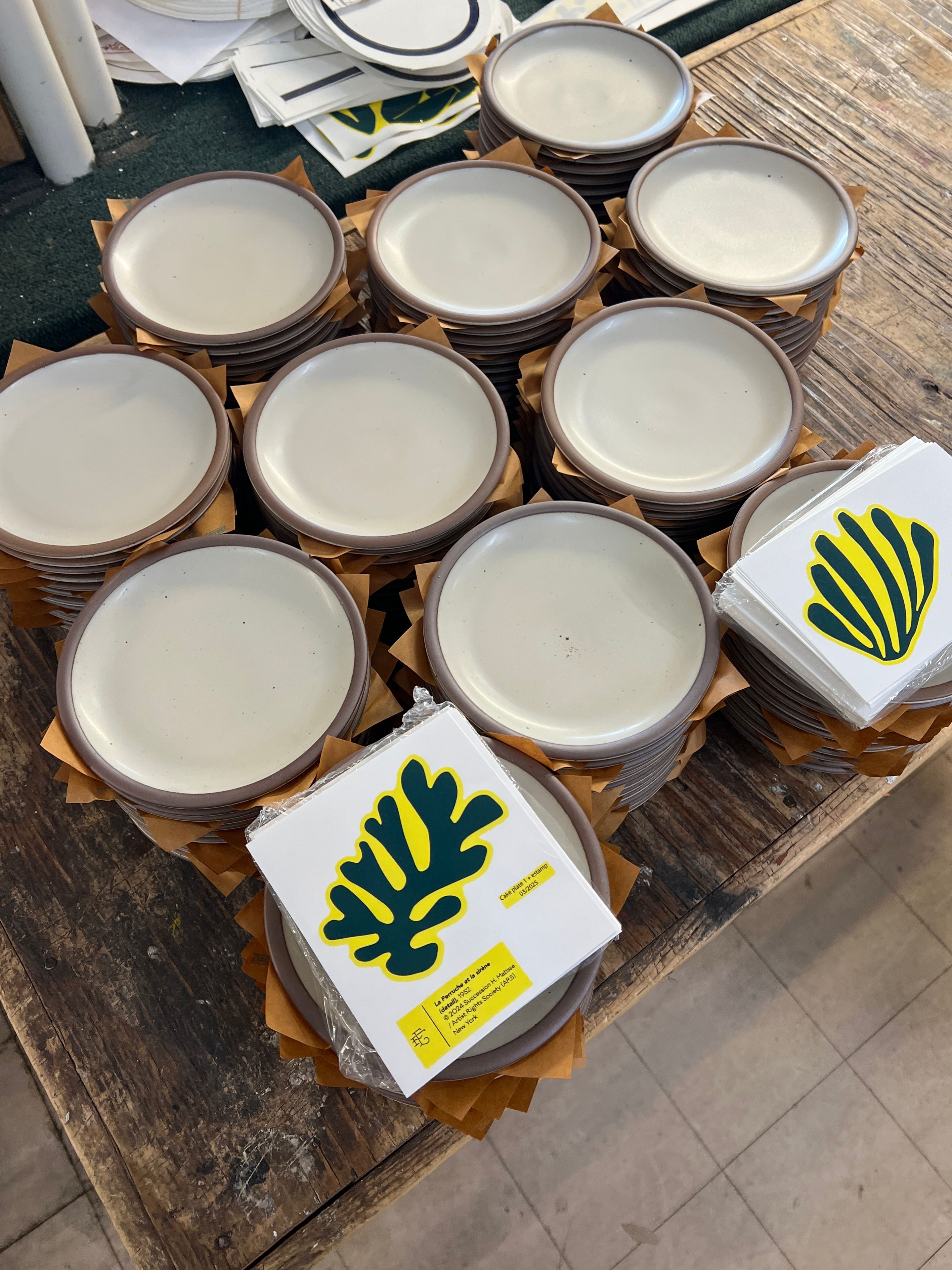 Stacks of off-white ceramic plates and decals next to them to be applied.