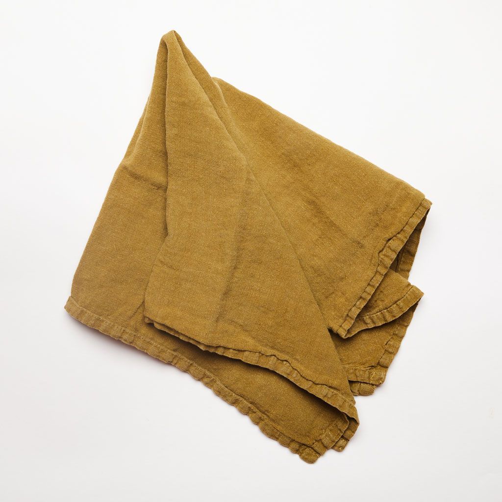A folded napkin that is linen and bronze in color