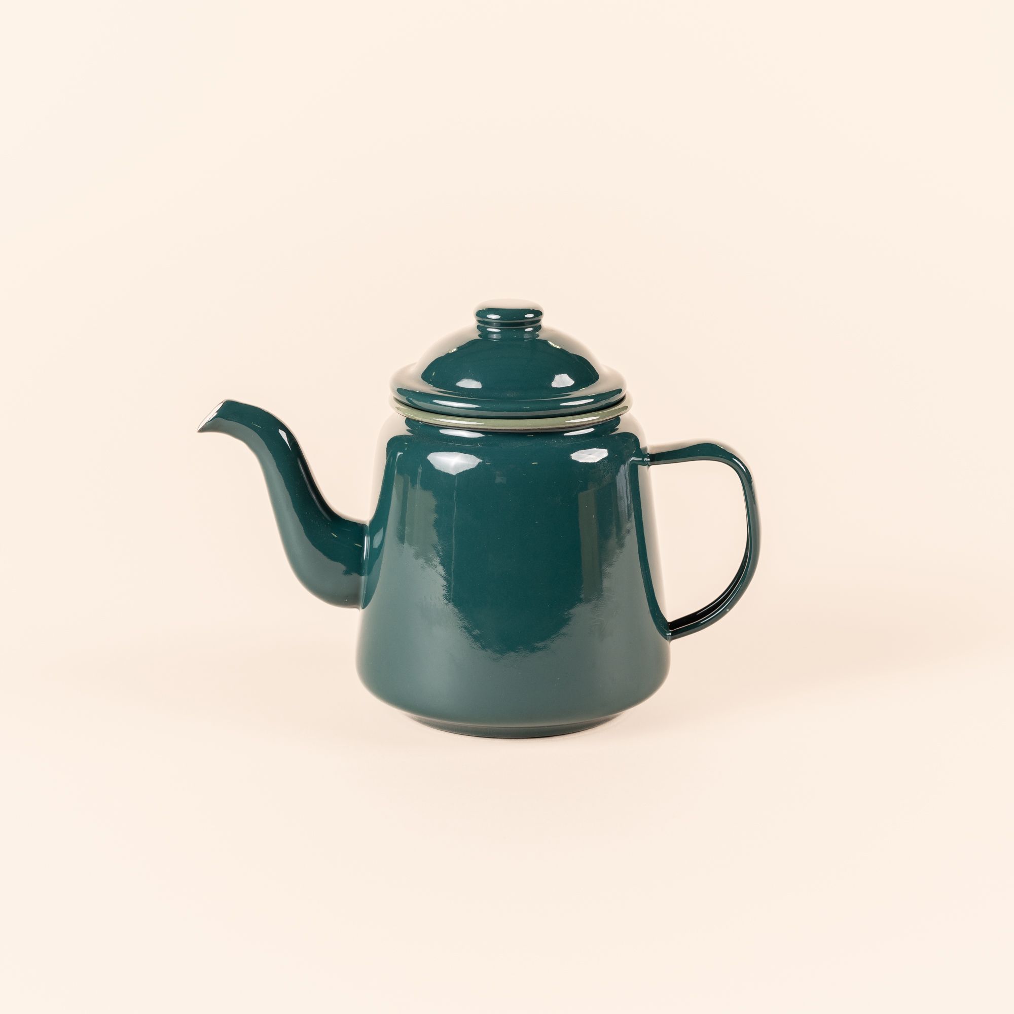 A deep dark teal enamel teapot with a thin handle, large spout, and simple lid