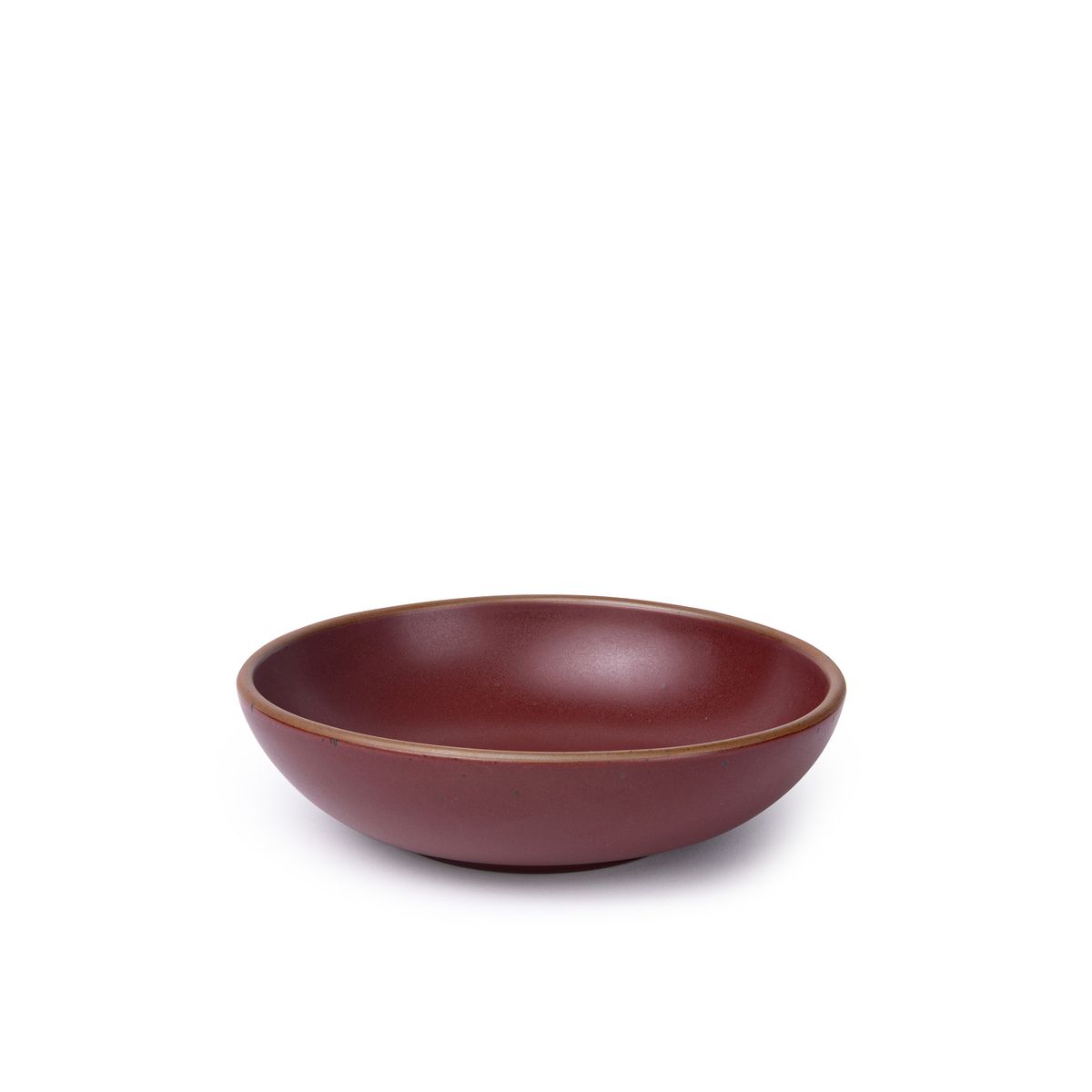 A dinner-sized shallow ceramic bowl in a plum color featuring iron speckles and an unglazed rim