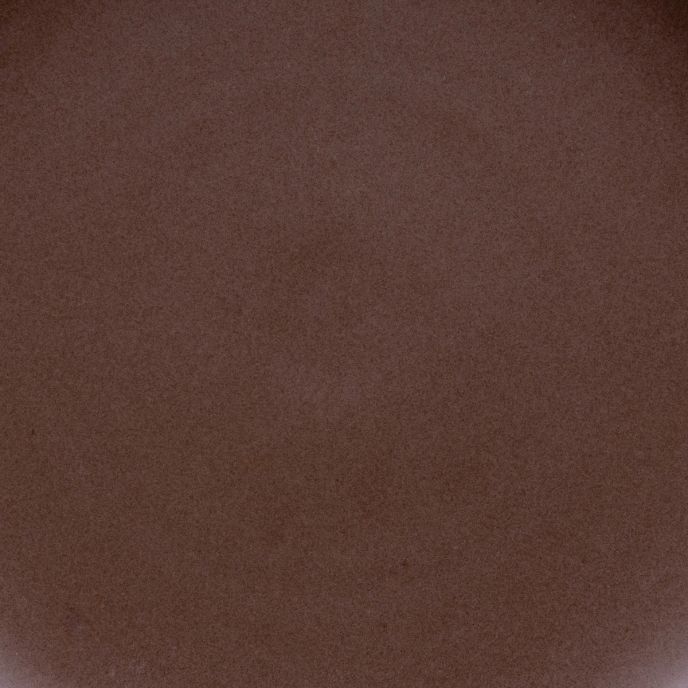 A closeup of a ceramic plate in a dark brown color