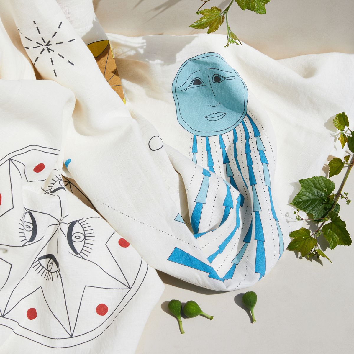 Close up of white tablecloth with surrealist planets, stars, and sky prints