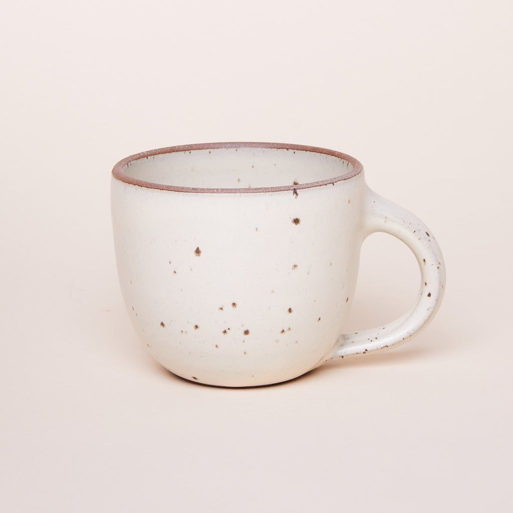 Sunday Morning Mug in Panna Cotta, an off-white color featuring iron speckles and an unglazed rim