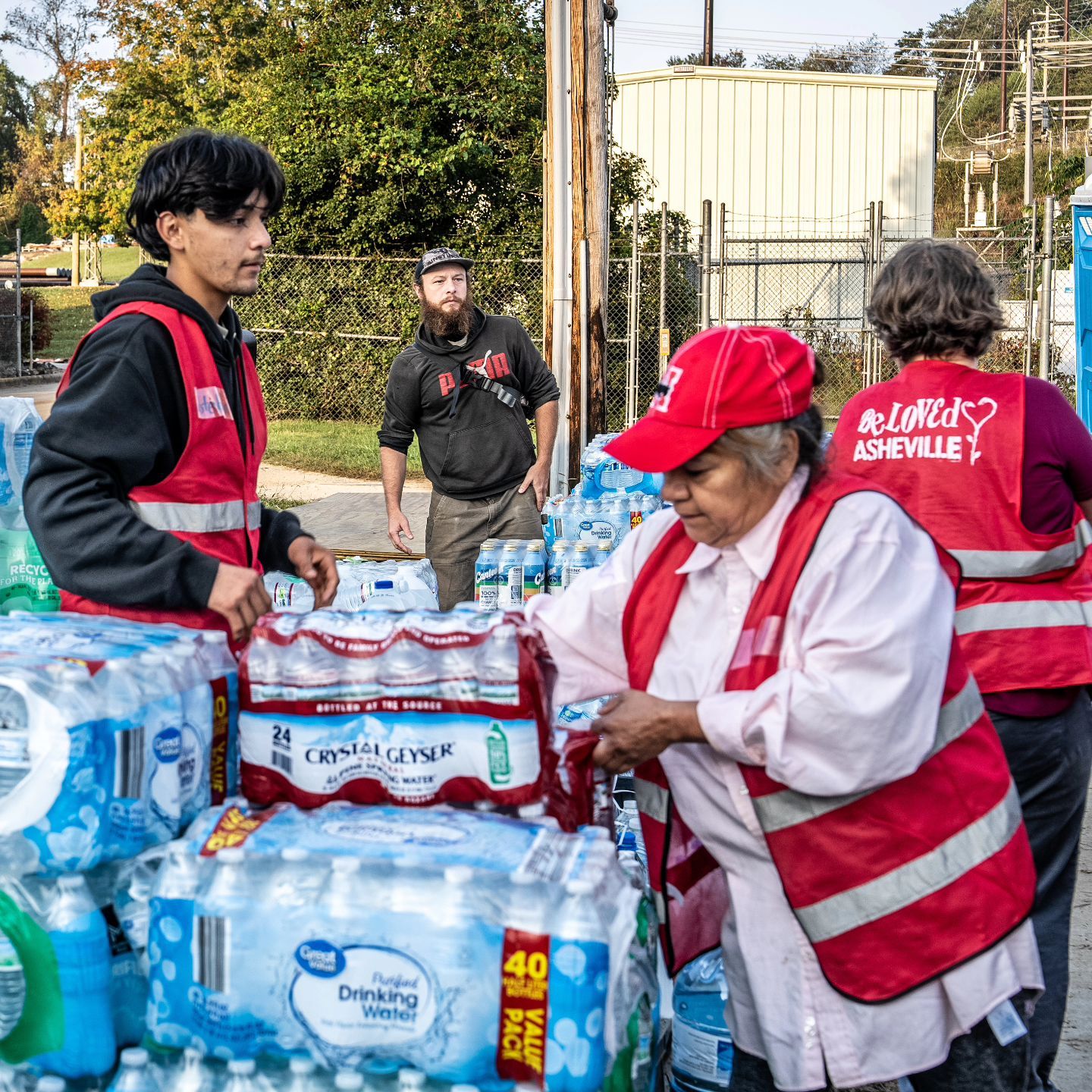 Outside, volunteers work together to distribute large cases of bottled water
