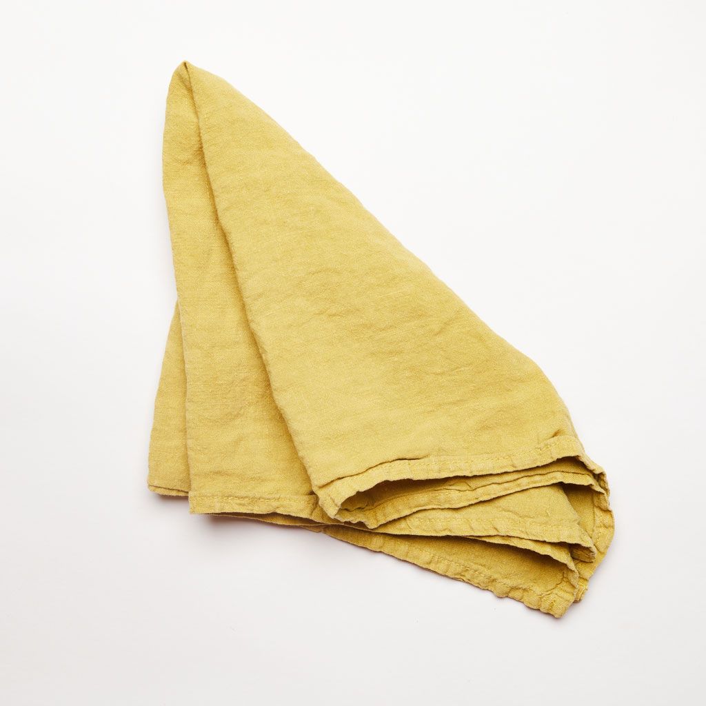 A draped napkin in mustard-colored linen