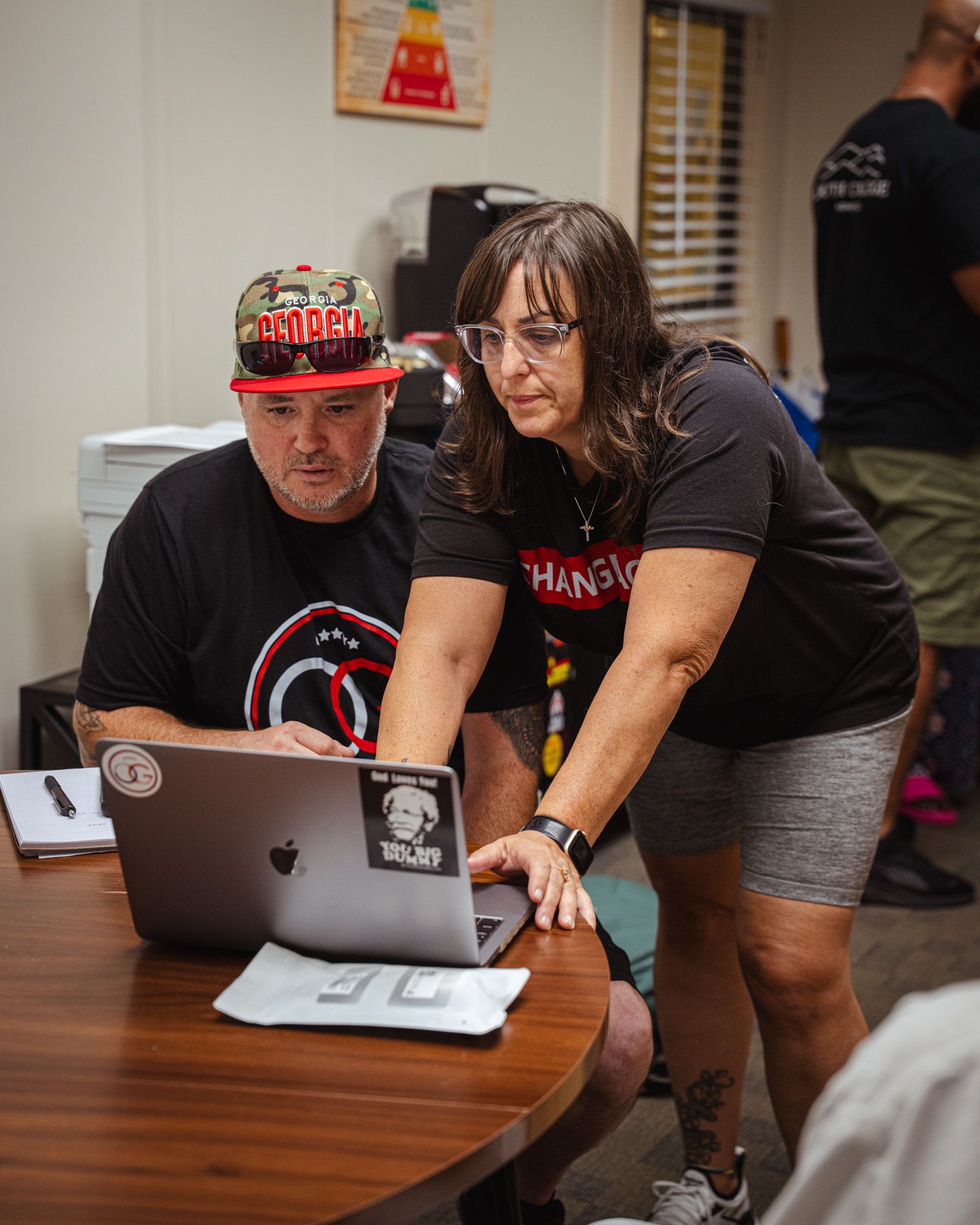 Two people work together in the Operation Gateway office staring at a computer.