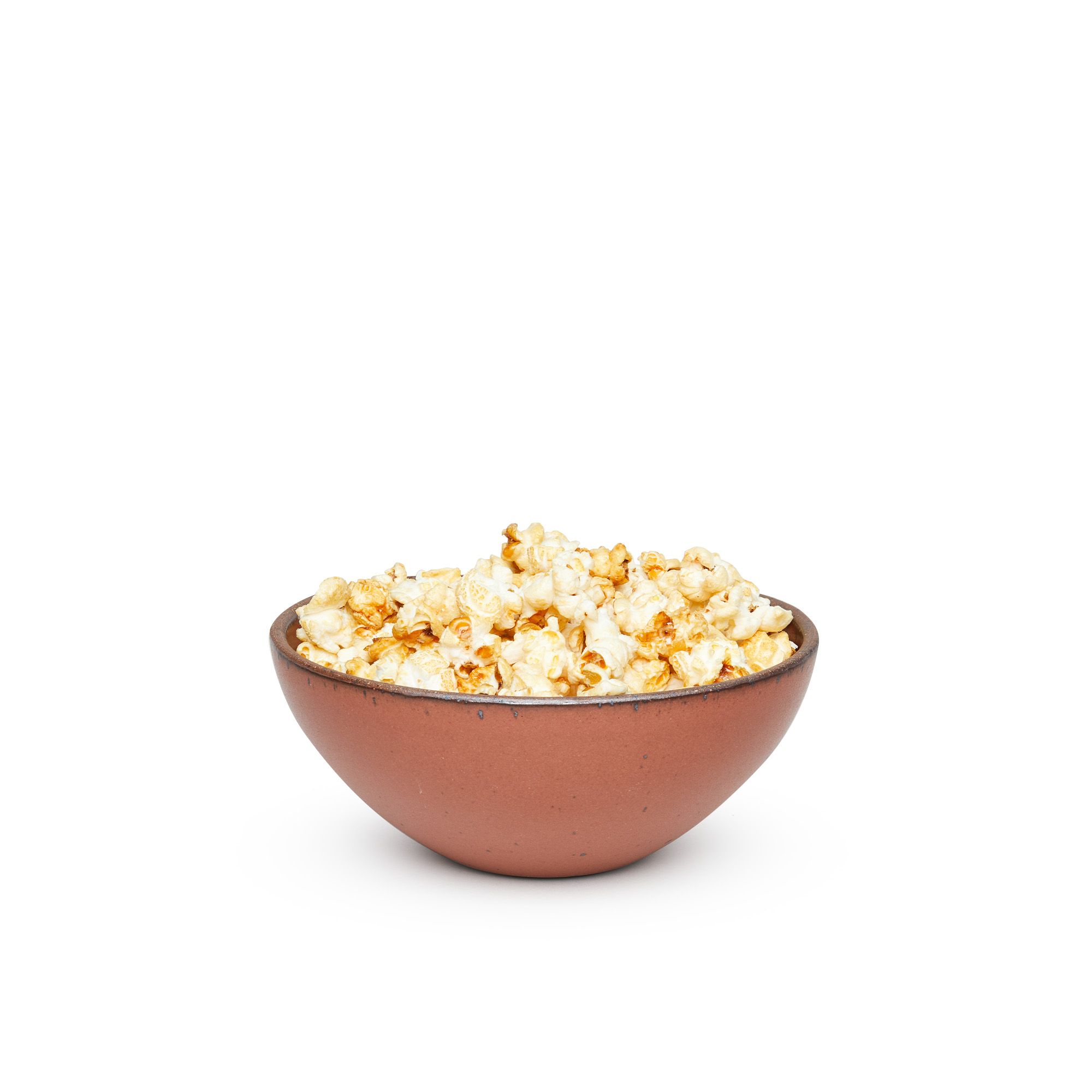 A medium rounded ceramic bowl in a cool burnt terracotta color featuring iron speckles and an unglazed rim, filled with popcorn