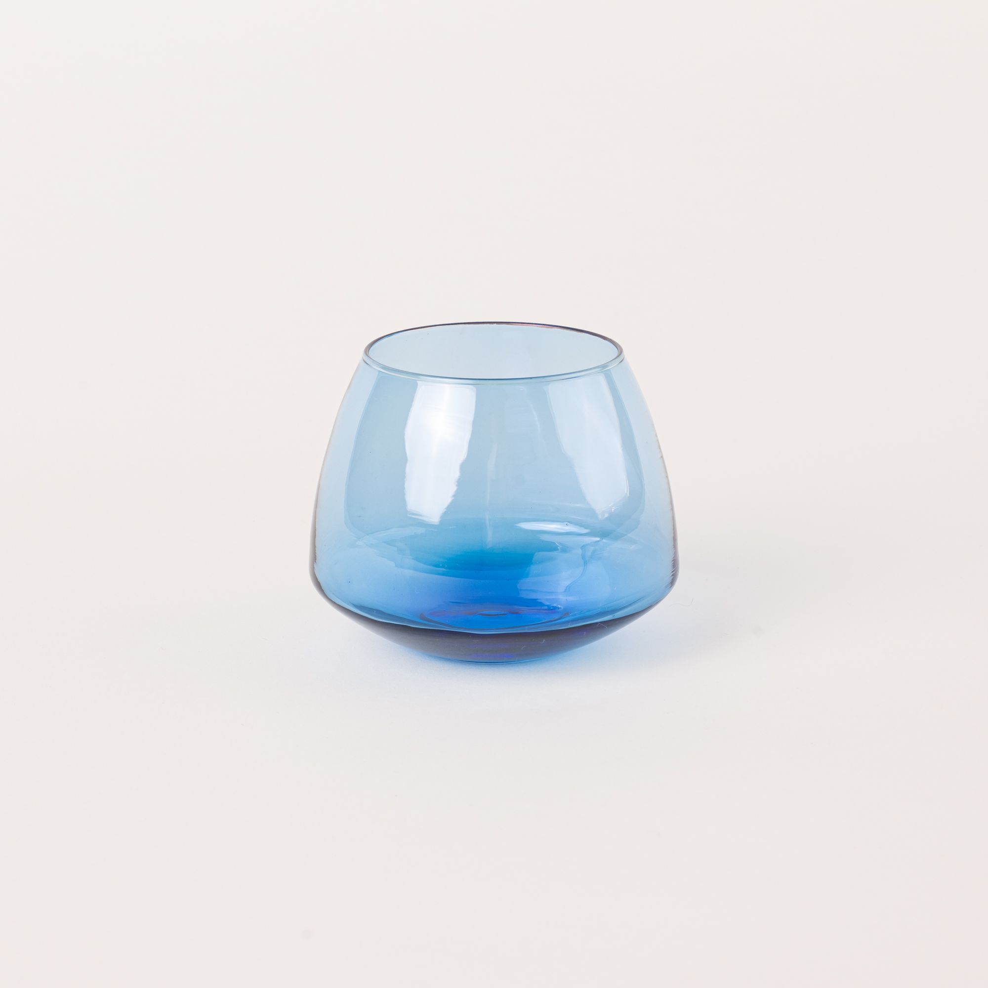 A light blue glass whiskey snifter with a rounded base