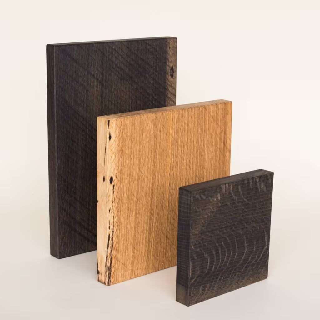 Three wood cutting boards in varying sizes in dark wood and light maple.