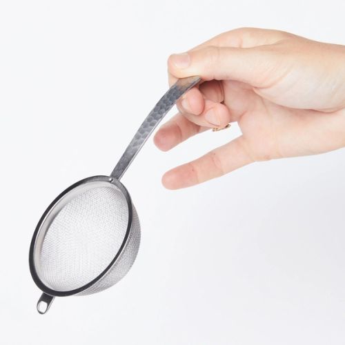 Hand holding handle of Stainless steel half dome strainer with steel handle