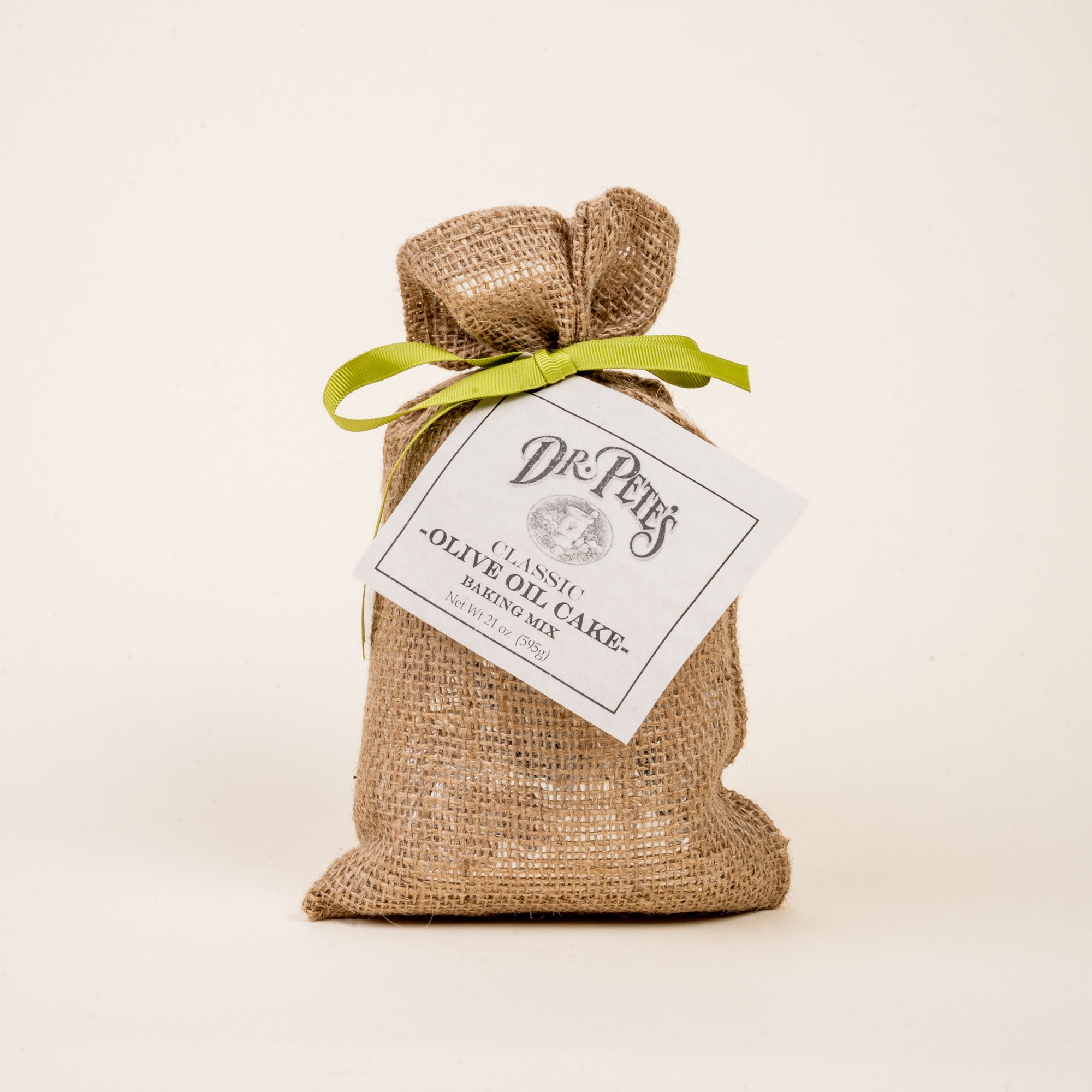 A burlap bag with a lime green ribbon and a label that reads "Dr. Pete's Classic Olive Oil Cake Mix'