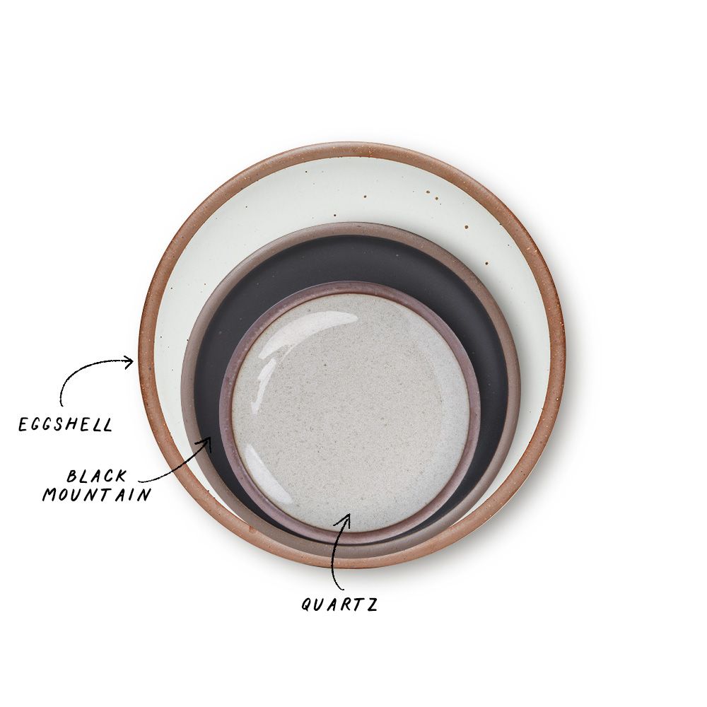 A stack of 3 plates in Dinner, Side, and Cake sizes in a cool white, graphite black, and reflective icy white colors.