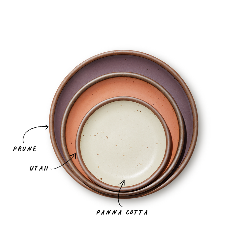 A stack of 3 plates in Dinner, Side, and Cake sizes in a muted purple, peach, and warm off-white colors.