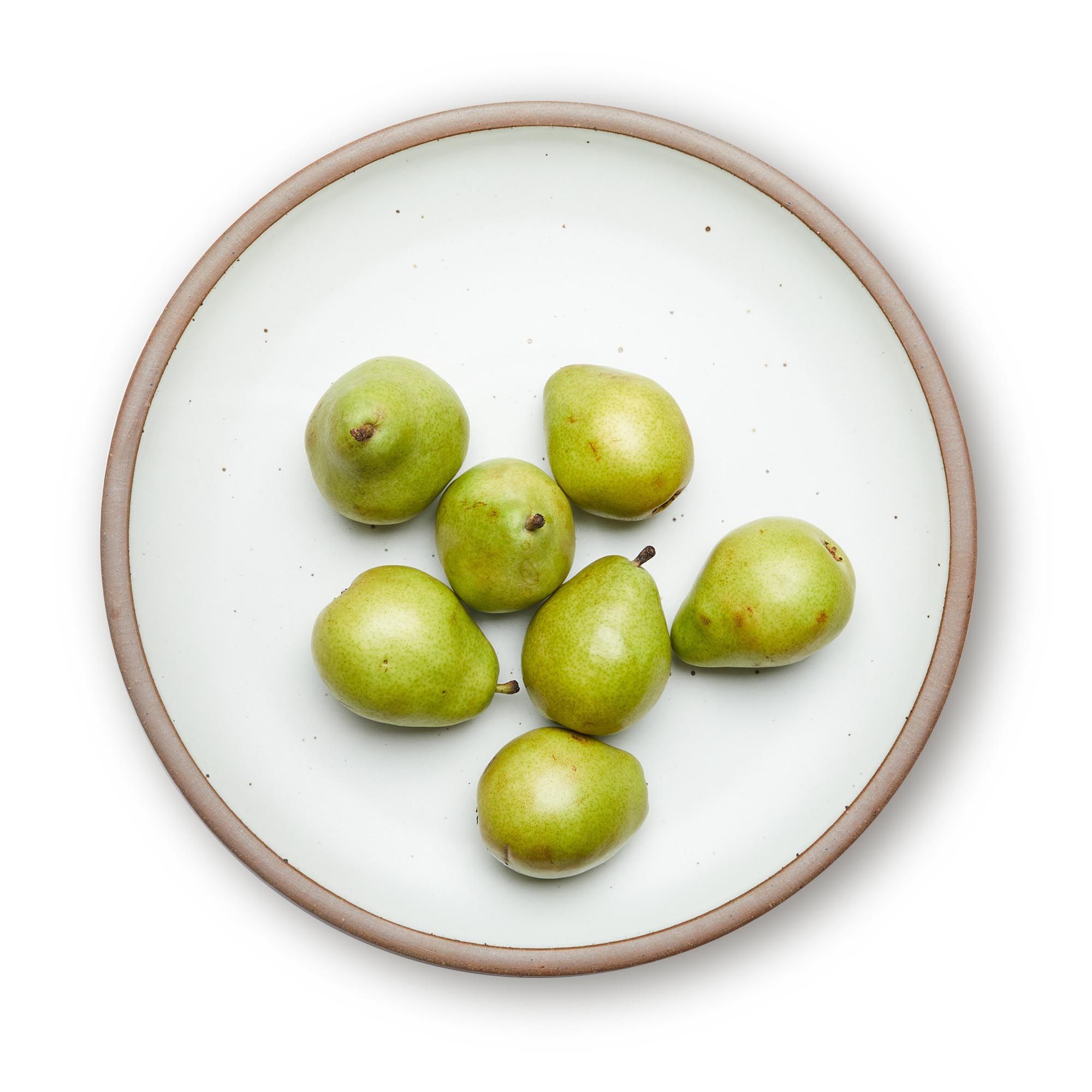 Pears on a large ceramic platter in a cool white color featuring iron speckles and an unglazed rim.