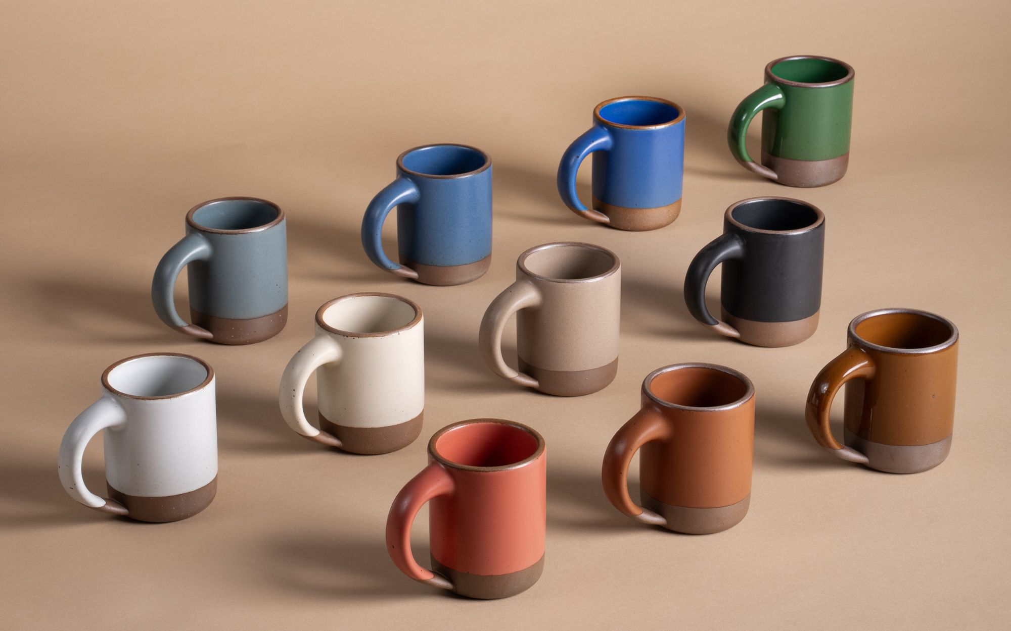 A lineup of East Fork Mugs in a rainbow of colors