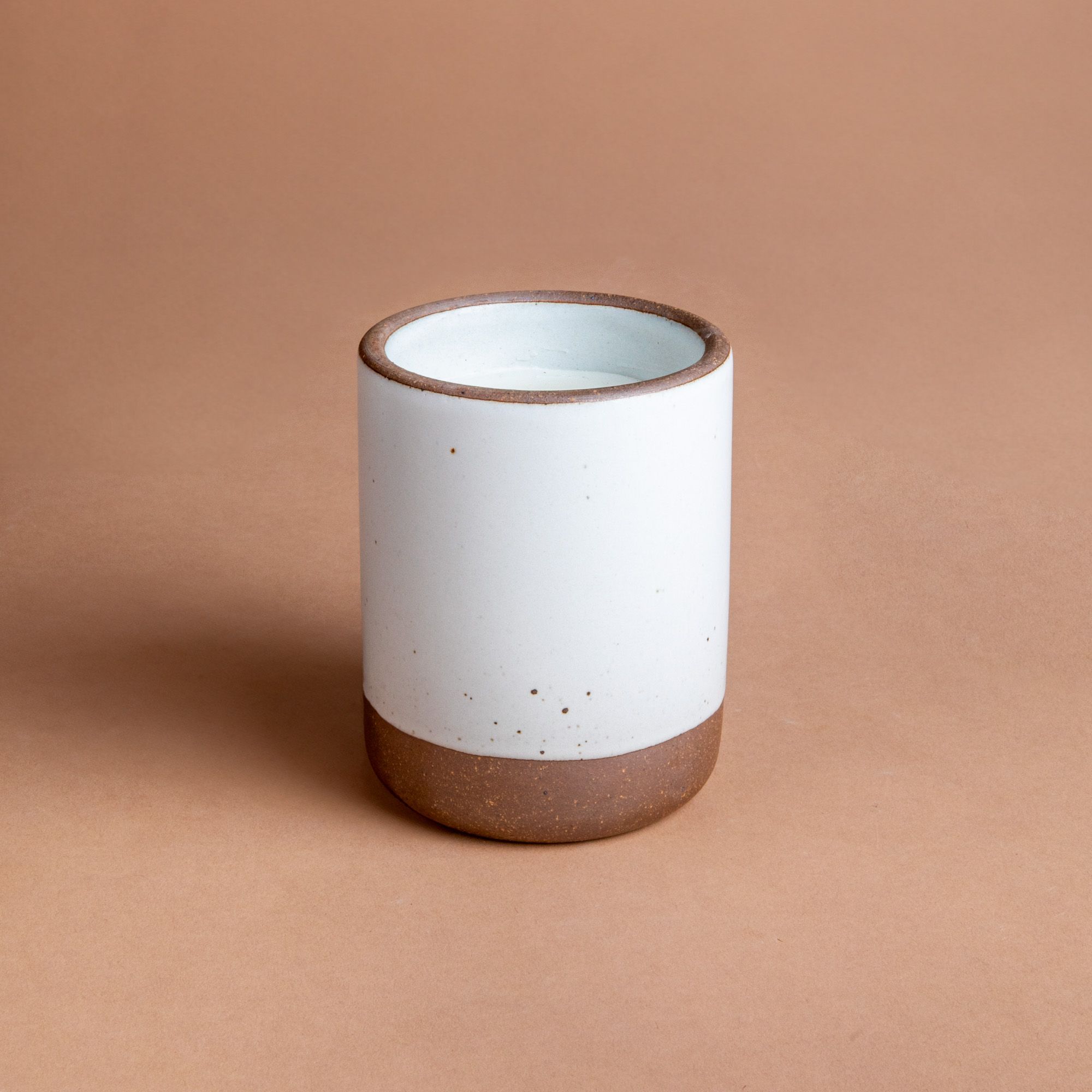 Large ceramic vessel in a cool white color with candle inside.