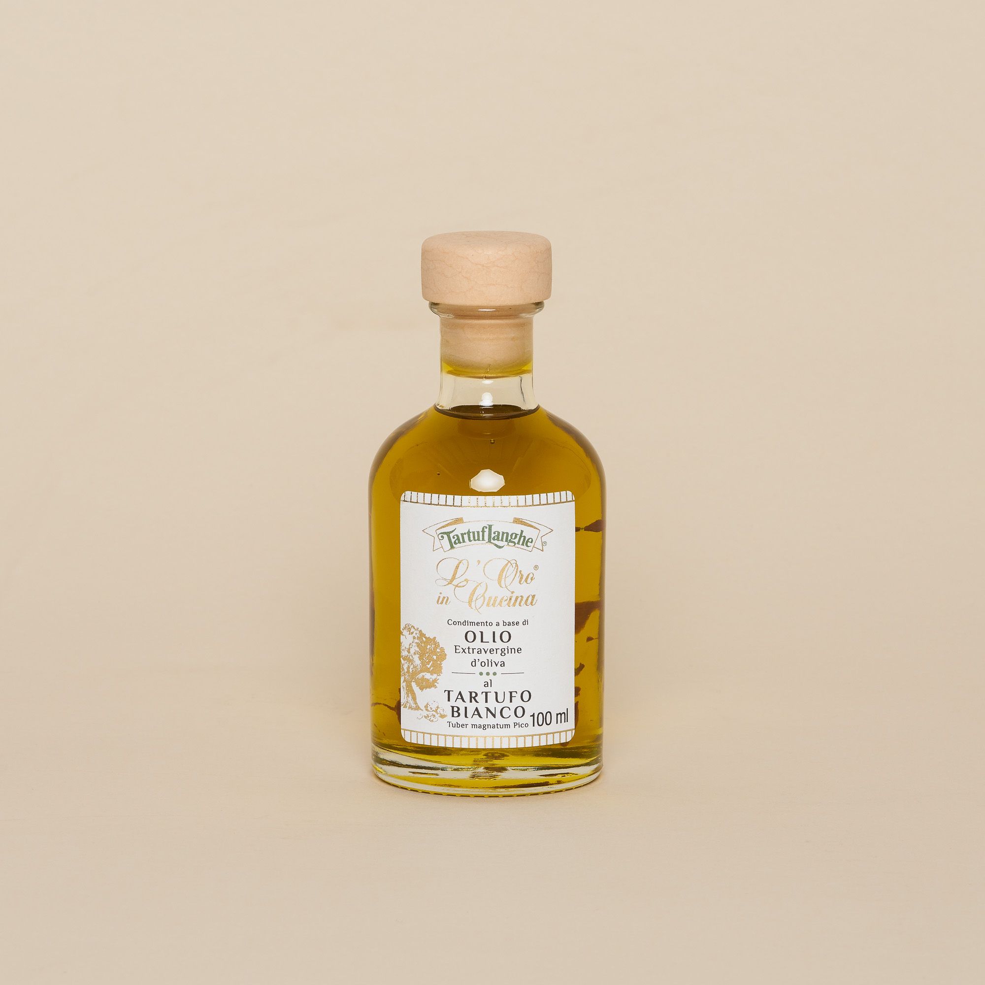 A small glass bottle of olive oil with a cork top. Tiny, the bottom sits comfortably in the palm of your hand. The label white, gold, green and done in a classic style.