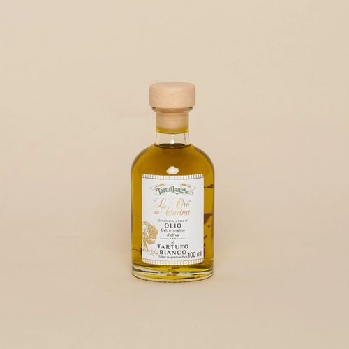 A small glass bottle filled with olive oil. The bottle is topped with a natural cork and adorned with a classical Italian styled label.