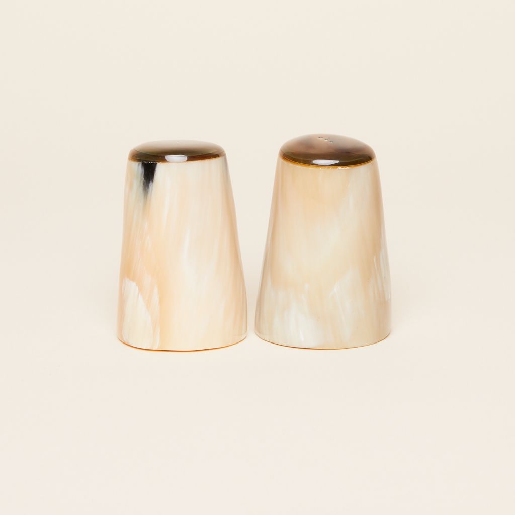 Two shakers for salt and pepper that are cylindrical and flare toward the base in various shades of brown