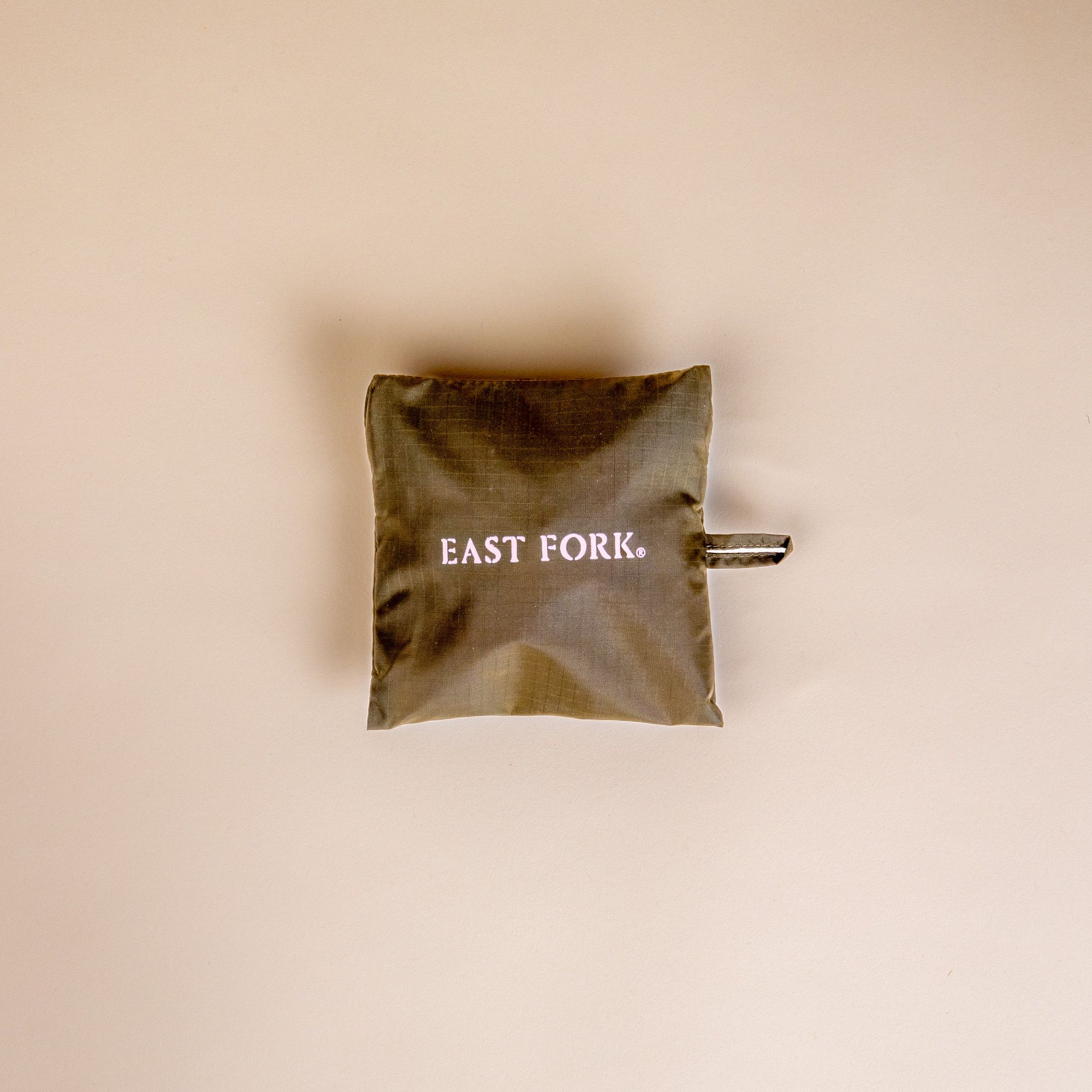 A little square bag that is dark olive and reads 'East Fork'.