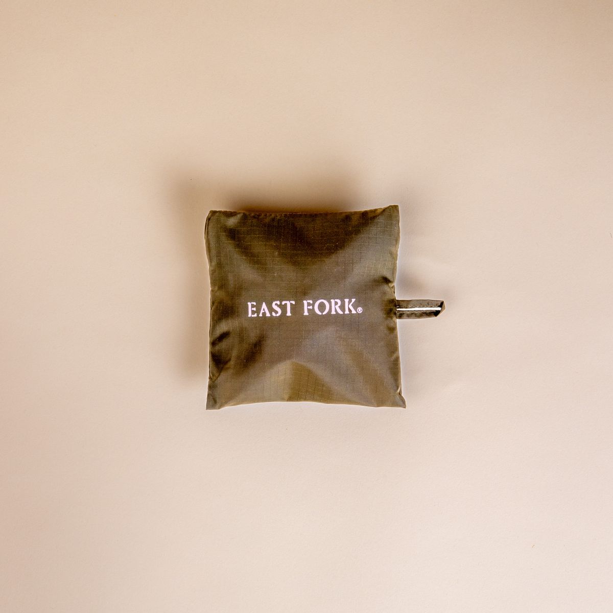 A little square bag that is dark olive and reads 'East Fork'. 