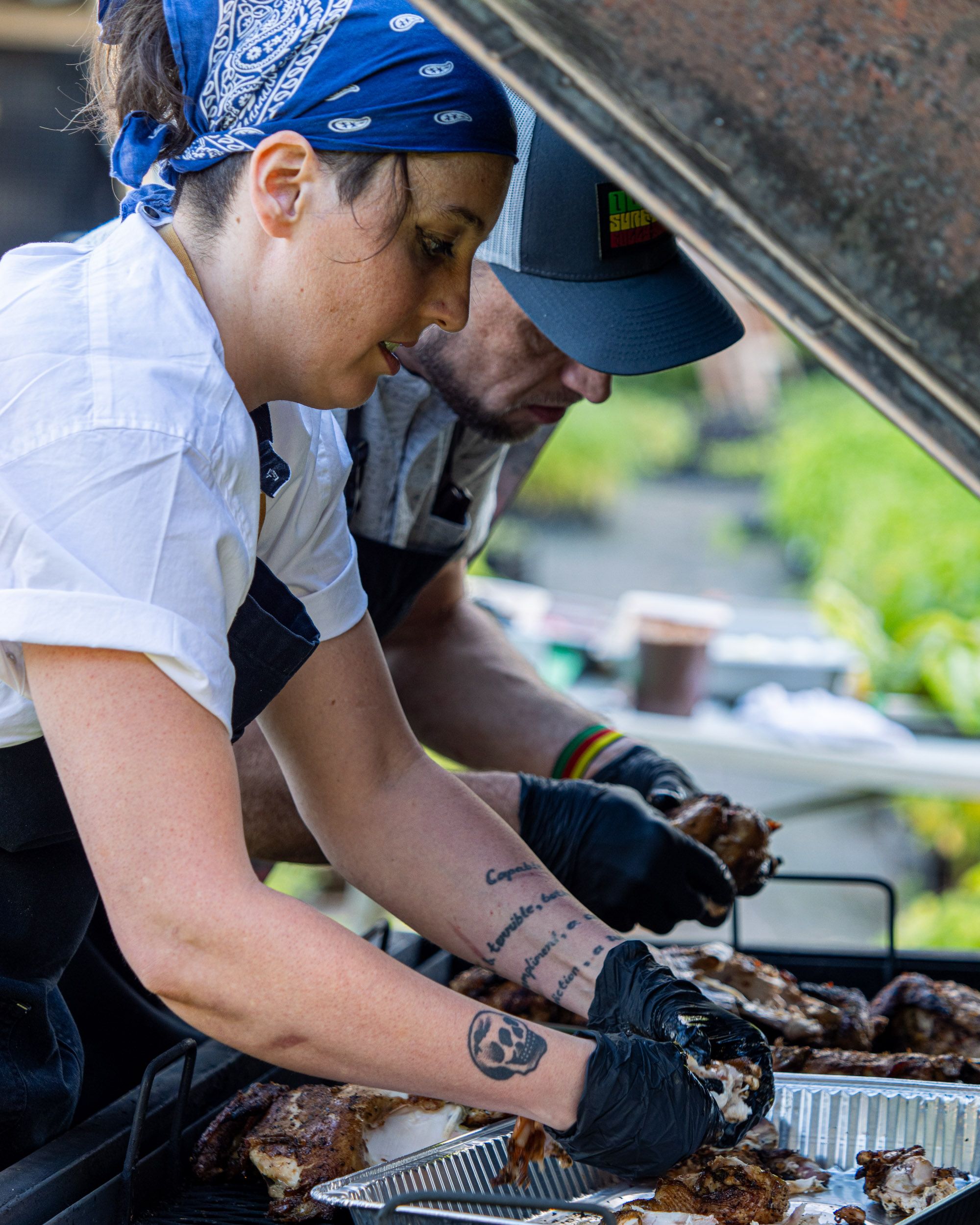 Outside, chefs are preparing meat for an aluminum serving tray