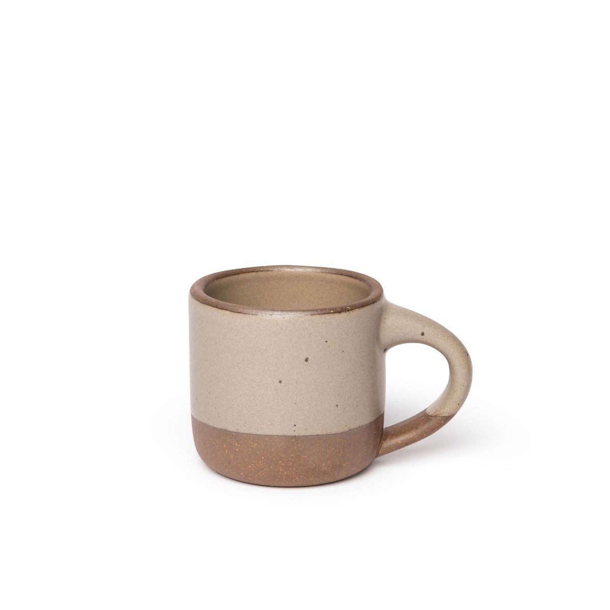 A small sized ceramic mug with handle in a warm pale brown glaze featuring iron speckles and unglazed rim and bottom base.