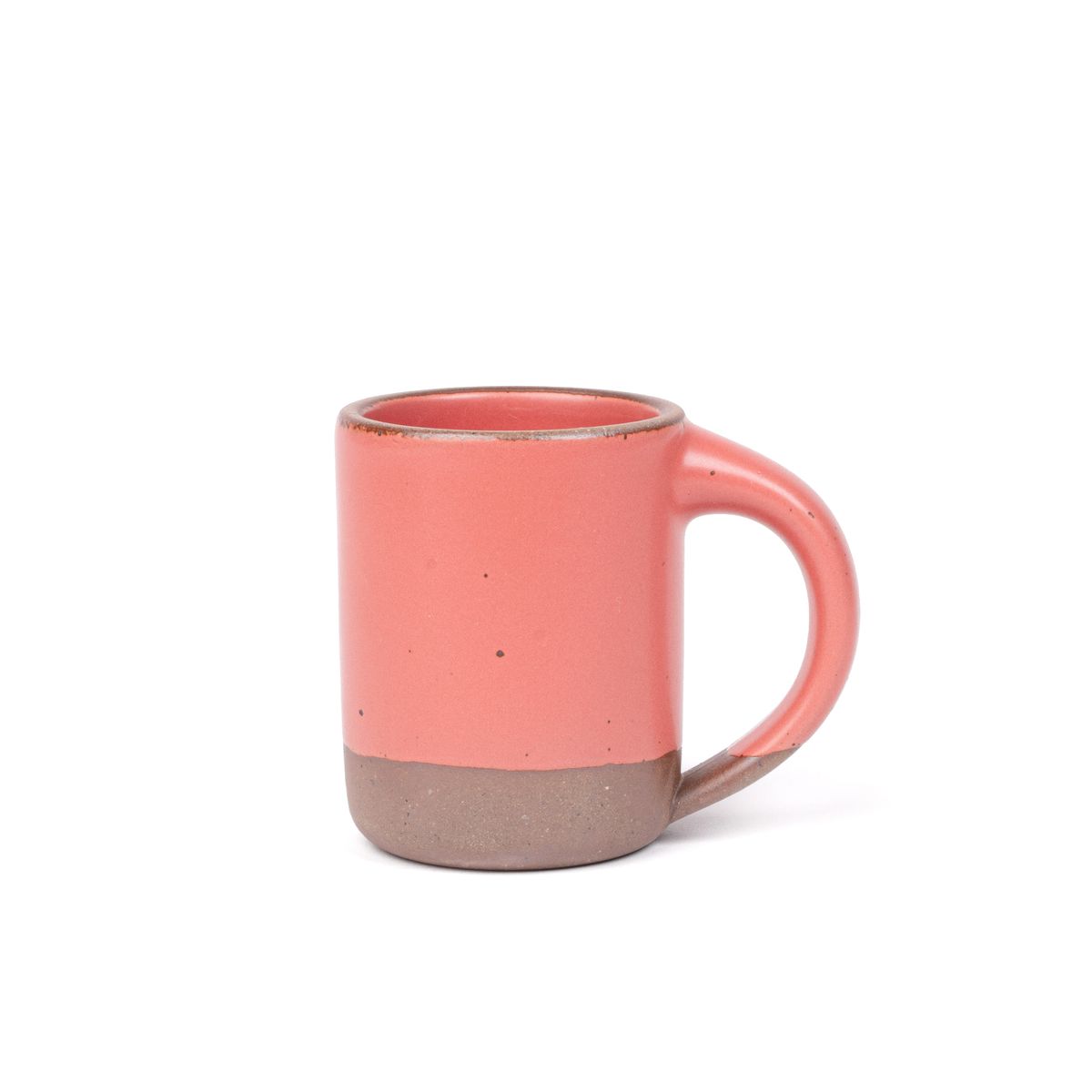 A medium sized ceramic mug with handle in a watermelon pink color featuring iron speckles and unglazed rim and bottom base.