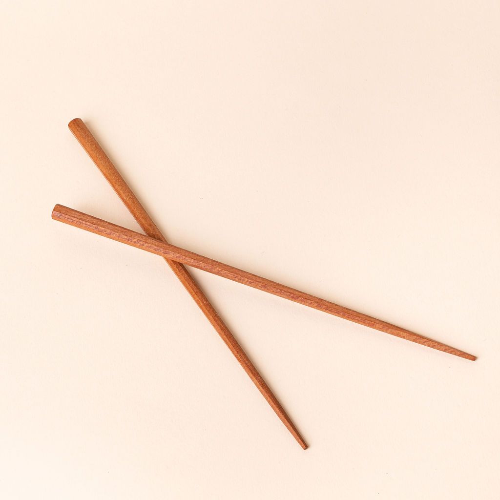 Simple pair of light brown wood chopsticks stacked over each other