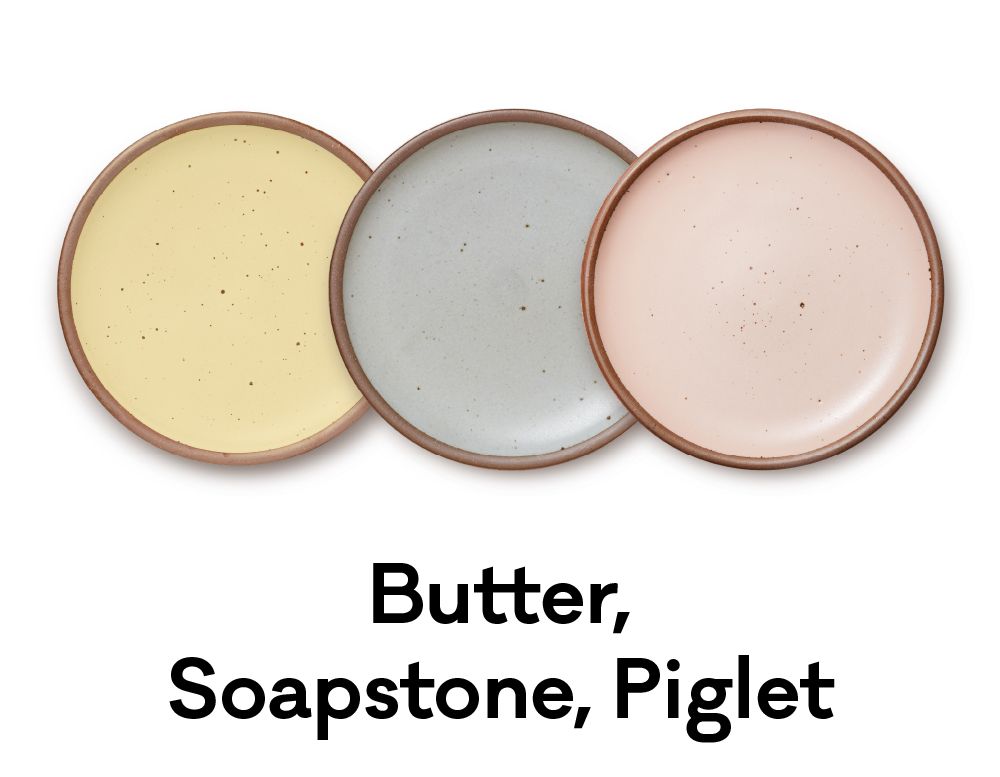 Soft yellow, blue and pink plates are positioned next to each other. Underneath it reads "Butter, Soapstone, Piglet"