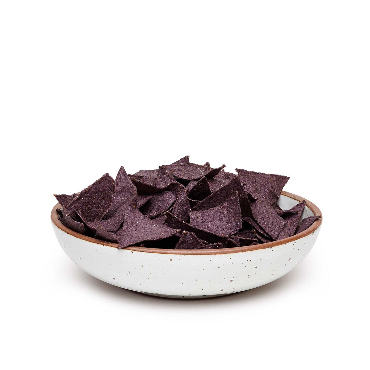 A large shallow serving ceramic bowl in a cool white color featuring iron speckles and an unglazed rim, filled with tortilla chips