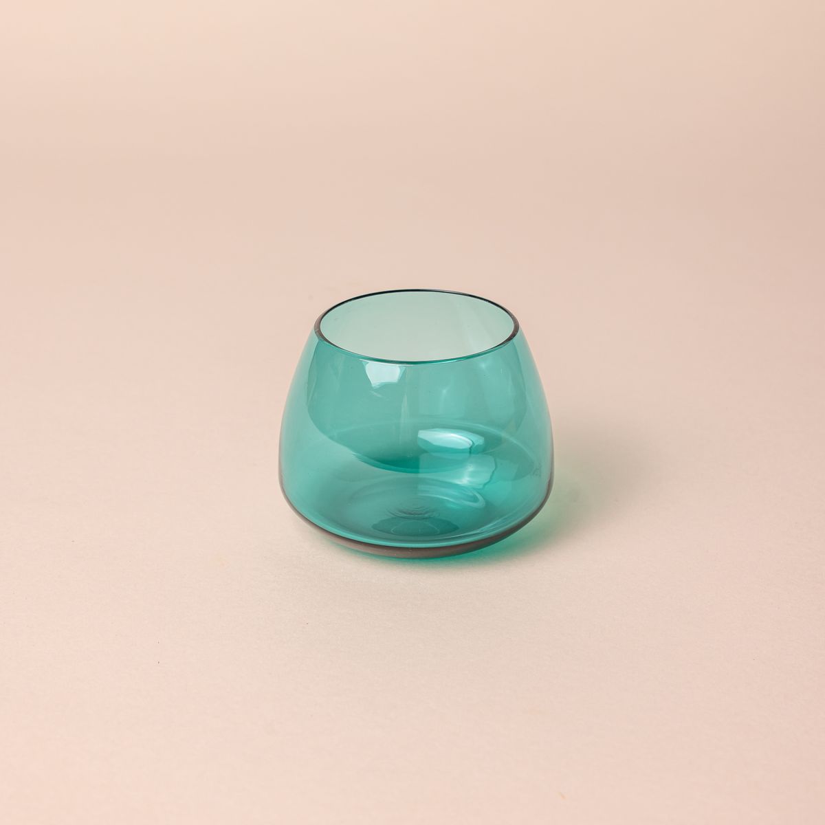 A round short aqua blue glass punch cup with a round base that narrows a bit near the top.