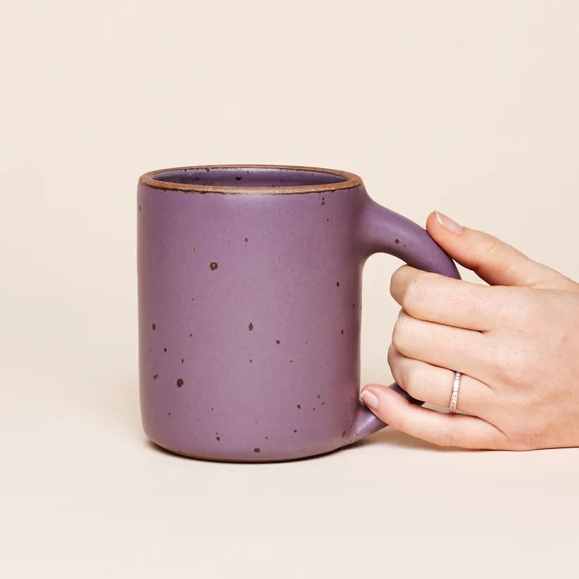 A big sized ceramic mug with handle in a purple color featuring iron speckles and unglazed rim